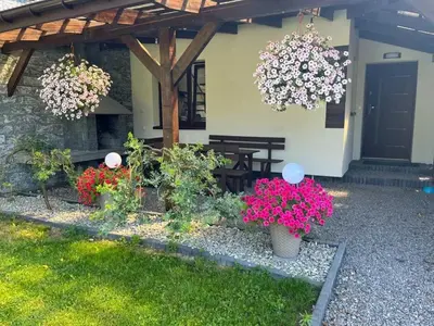 a garden with flowers in front of a house at Domek u Gosi