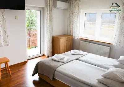 a bedroom with two twin beds and a lamp at Noclegi Jaroszowice in Jaroszowice