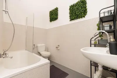 a bathroom with a white bath tub and a sink at Vintage Soul Ariańska in Kraków