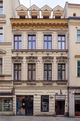 a large stone building with windows on a street at Imaginibus by MB Apartments in Kraków