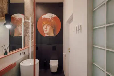 a bathroom with a toilet and posters on the wall at Imaginibus by MB Apartments in Kraków
