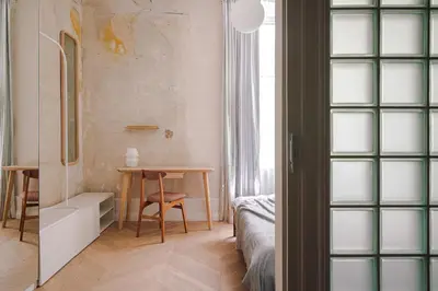 a small room with a table and a bedroom at Imaginibus by MB Apartments in Kraków