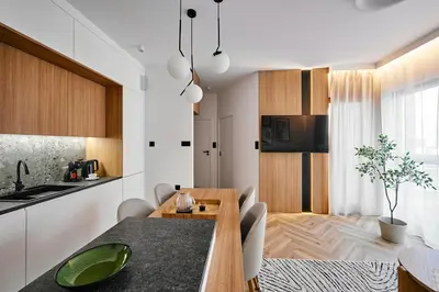 a kitchen and dining room with a table and chairs at Verde Dreams Apartment in Kraków