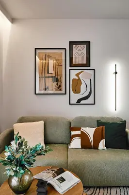 a living room with a couch and framed pictures on the wall at Verde Dreams Apartment in Kraków