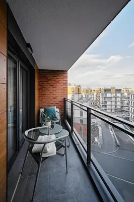a balcony with a table and a view of a city at Verde Dreams Apartment in Kraków
