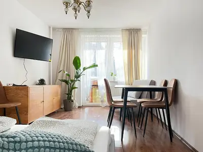 a living room with a dining room table with chairs at Apartment for 7 guests in the city of Cracow in Kraków