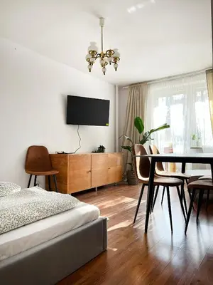a bedroom with a bed and a table and a tv at Apartment for 7 guests in the city of Cracow in Kraków