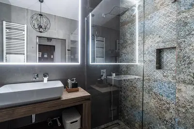 a bathroom with a sink and a glass shower at RentPlanet - Apartament Rakowicka in Kraków