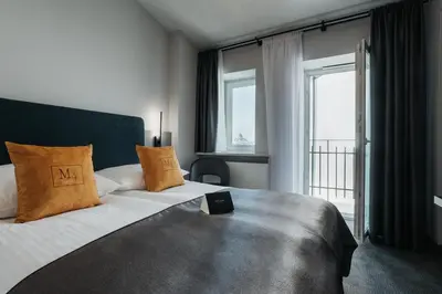 a room with a desk with a television and a chair at Hotel M4 Boutique in Kraków