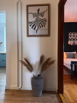a vase with a plant in the corner of a room at The Nest, Apartament in Oświęcim