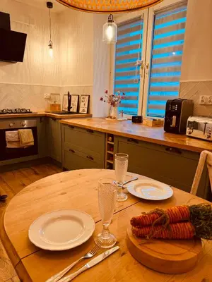 a wooden table with plates and glasses on top of it at The Nest, Apartament in Oświęcim
