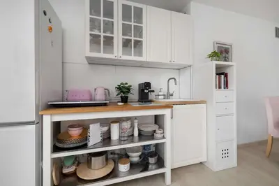 a kitchen with white cabinets and a counter with dishes at Bright Apartment in Kraków Perfect for Remote Work by Noclegi Renters in Kraków