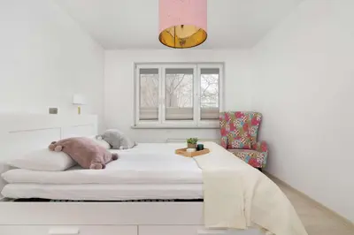 a bedroom with a bed with a stuffed animal on it at Bright Apartment in Kraków Perfect for Remote Work by Noclegi Renters in Kraków