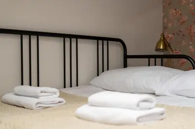a bed with three towels on top of it at Parkside Design Loft in Kraków