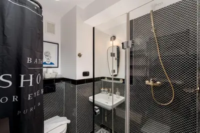 a black and white bathroom with a shower and a sink at Parkside Design Loft in Kraków