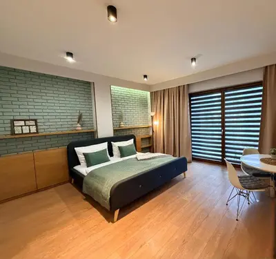 a bedroom with a bed and a table and chairs at Apartament Rakowicka in Kraków