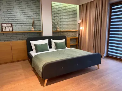 a bedroom with a large bed with green and white pillows at Apartament Rakowicka in Kraków