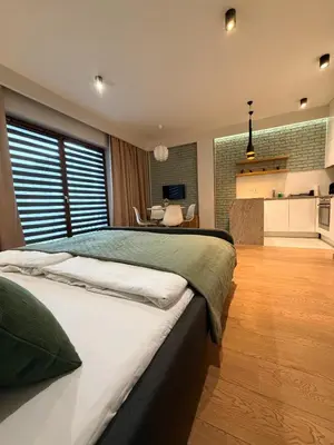 a large bedroom with a large bed and a kitchen at Apartament Rakowicka in Kraków