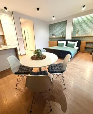 a room with a bed and a table and chairs at Apartament Rakowicka in Kraków