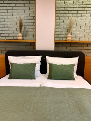a bed with two green pillows on top of it at Apartament Rakowicka in Kraków