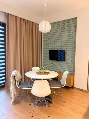 a dining room with a table and chairs and a tv at Apartament Rakowicka in Kraków