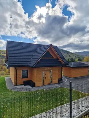 a log home with a black roof at Domek Jaworówka in Zawoja