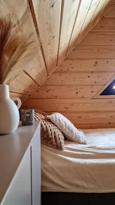 a bed in a room with a wooden ceiling at Domek Jaworówka in Zawoja