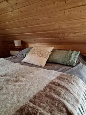 a bed with pillows on it in a room at Domek Jaworówka in Zawoja