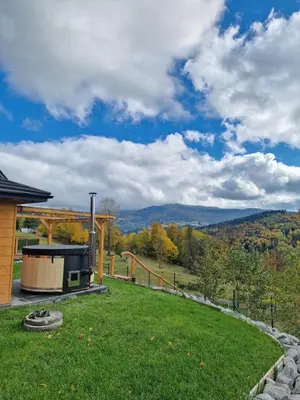 a backyard with a grill and a view of the mountains at Domek Jaworówka in Zawoja