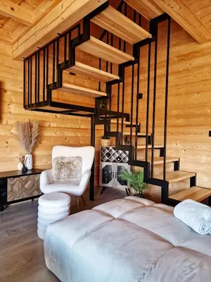 a bedroom with a large bed and a staircase at Domek Jaworówka in Zawoja