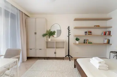 a white bedroom with a bed and a mirror at Prokocim Superior Apartment by BookingHost in Kraków
