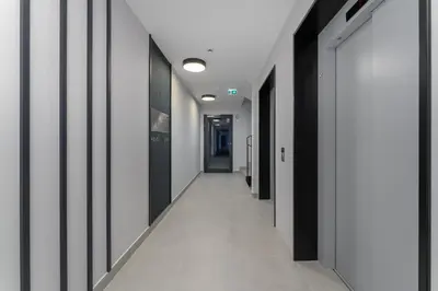 a hallway with white walls and black and white doors at Prokocim Superior Apartment by BookingHost in Kraków