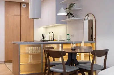 a kitchen with a table and chairs in a room at Prokocim Superior Apartment by BookingHost in Kraków
