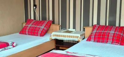 two beds with red and blue pillows in a room at Kwatery prywatne Noclegi pracownicze in Wola Batorska
