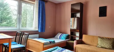 a small room with a bed and a chair and a window at Kwatery prywatne Noclegi pracownicze in Wola Batorska