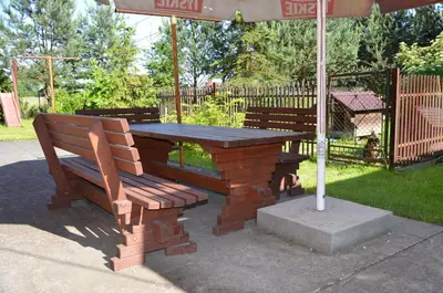 a picnic table and bench under an umbrella at Kwatery prywatne Noclegi pracownicze in Wola Batorska