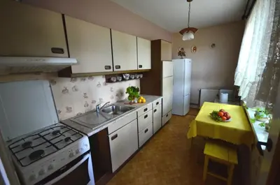 a kitchen with a sink and a stove and a table at Kwatery prywatne Noclegi pracownicze in Wola Batorska