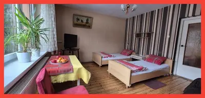 a living room with two beds and a table at Kwatery prywatne Noclegi pracownicze in Wola Batorska