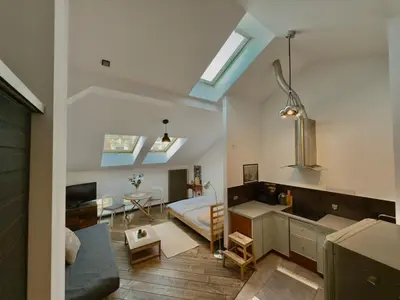 a bedroom with a bed and a kitchen with skylights at Stylish 1BR for 4 in Old Town - Main Square in Kraków