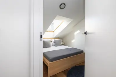 a bedroom with a bed and a skylight at 4 Bedroom apartment with a balcony - Trynitarska 6 in Kraków