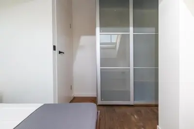 a bedroom with a glass closet and a bed at 4 Bedroom apartment with a balcony - Trynitarska 6 in Kraków