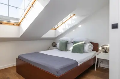a bedroom with a bed in a attic at 4 Bedroom apartment with a balcony - Trynitarska 6 in Kraków