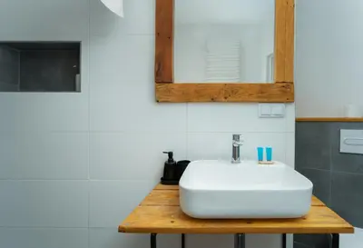 a bathroom with a white sink and a mirror at Wawel Kossak Residence Loft Studio by BookingHost in Kraków
