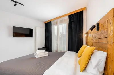 a bedroom with a large bed with yellow pillows at Wawel Kossak Residence Loft Studio by BookingHost in Kraków