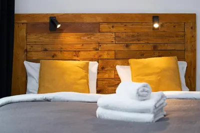 a bed with towels on it with yellow pillows at Wawel Kossak Residence Loft Studio by BookingHost in Kraków