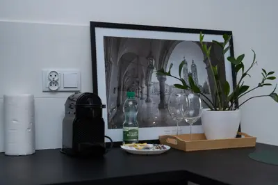 a table with a bottle and a plate of food and glasses at Wawel Kossak Residence Loft Studio by BookingHost in Kraków