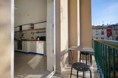 a balcony with a table and a view of a kitchen at Downtown Cozy Corner in Kraków