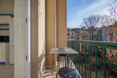 a balcony with a stool and a view of a city at Downtown Cozy Corner in Kraków