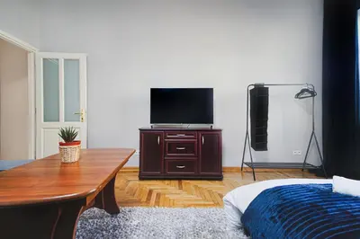 a living room with a tv on a wooden dresser at Downtown Cozy Corner in Kraków