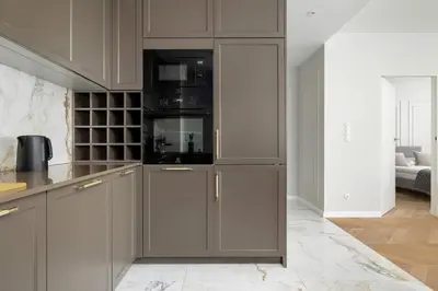 a kitchen with gray cabinets and black appliances at Atmospheric Apartment with Ideal Location in Cracow by Noclegi Renters in Kraków